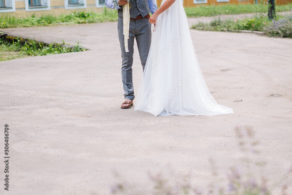 Obraz premium Wedding in the style rustic. The bride and groom in summer outdoor. Groom embracing bride. Girl puts her hand on men's shoulder, in green park.