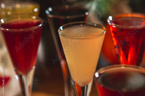 Set of glasses with different colored tinctures made on the basis of fruits and alcohol, a wonderful aperitif before the festive dinner