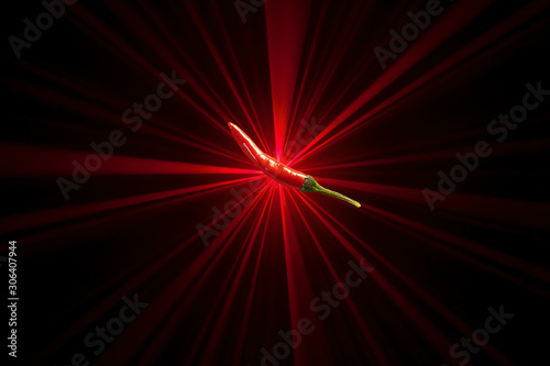 red chili pepper, on top of laser light beams background