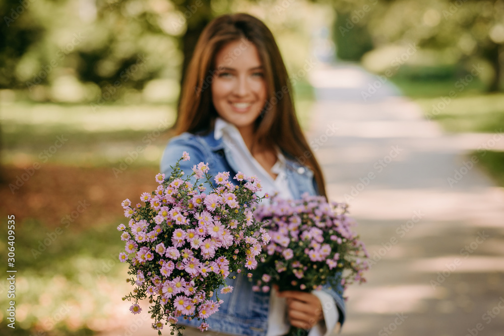 Beautiful woman in park with bouquet of flowers Beautiful woman in park with bouquet of flowers