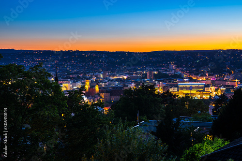 Germany, Skyline and magical glowing lights of houses of city stuttgart from above by night after colorful sunset in summer atmosphere