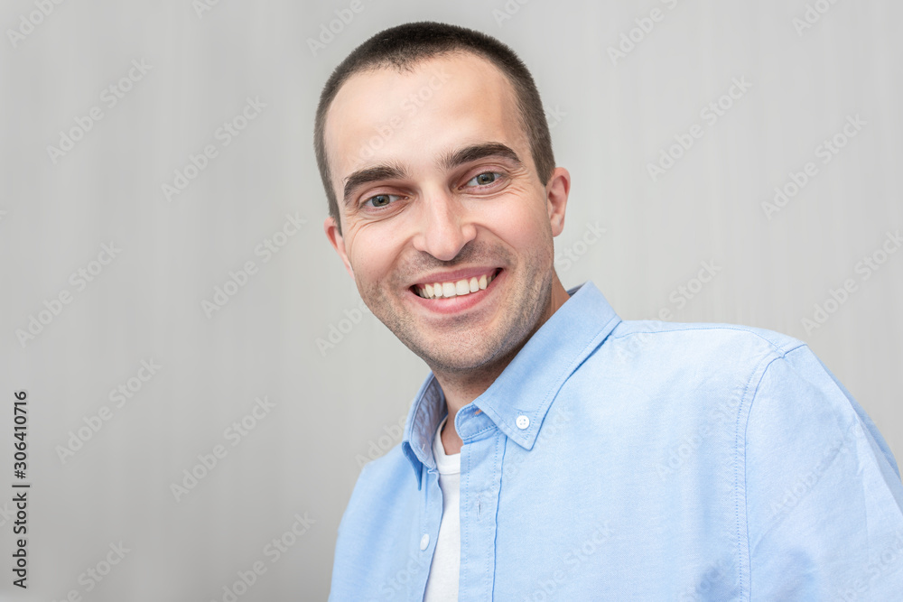 Attractive young man smiling and looking in the camera, portrait, close up, toned Attractive young man smiling and looking in the camera, portrait, close up, toned