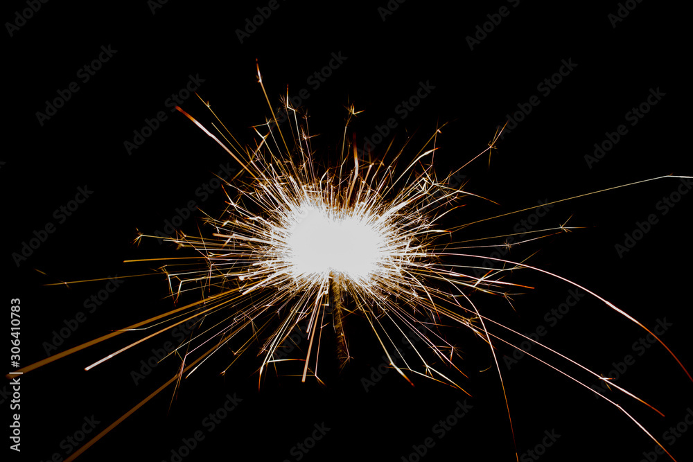 Sparkler in honor of the holiday on a black background. Merry Christmas