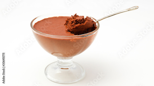 Chocolate mousse and tea spoon in a transparent bowl on a white backgroun photo