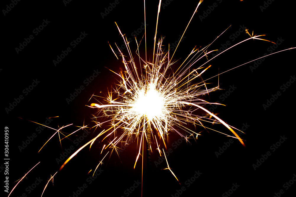 Sparkler in honor of the holiday on a black background. Merry Christmas