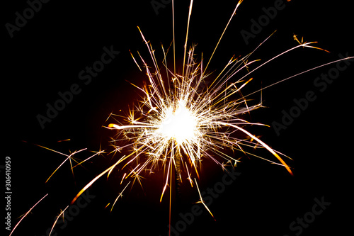 Sparkler in honor of the holiday on a black background. Merry Christmas