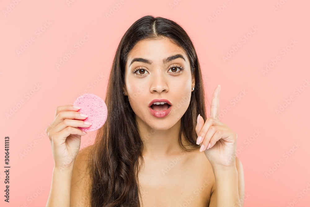 Young indian woman holding a facial skin care disc having some great idea, concept of creativity. Young indian woman holding a facial skin care disc having some great idea, concept of creativity.