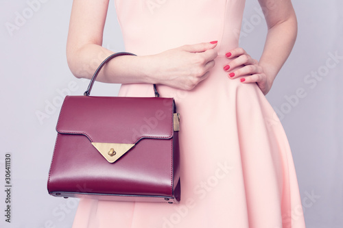 Young girl with handbag, women's hands, cropped image, toned
