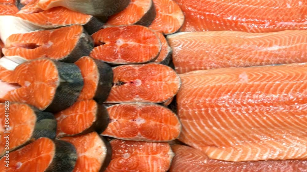 Seafood shop. Fresh fillet, chopped raw salmon, cut into pieces lies on store counter for sale. Food background. Close-up. Seafood shop. Fresh fillet, chopped raw salmon, cut into pieces lies on store counter for sale. Food background. Close-up.