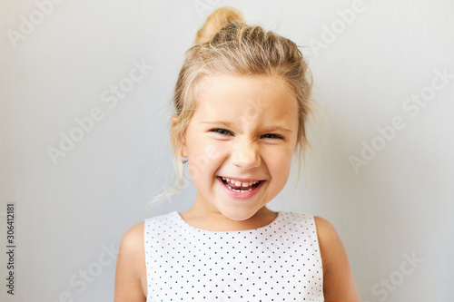 Joy, postive emotions and happy childhood concept. Beautiful adorable baby girl exclaiming excitedly, being overjoyed because she is going to amusement park, cinema or shopping, laughing out loud photo