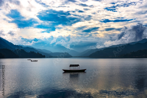 A single row Boat parked in middle of Phewa Lake.