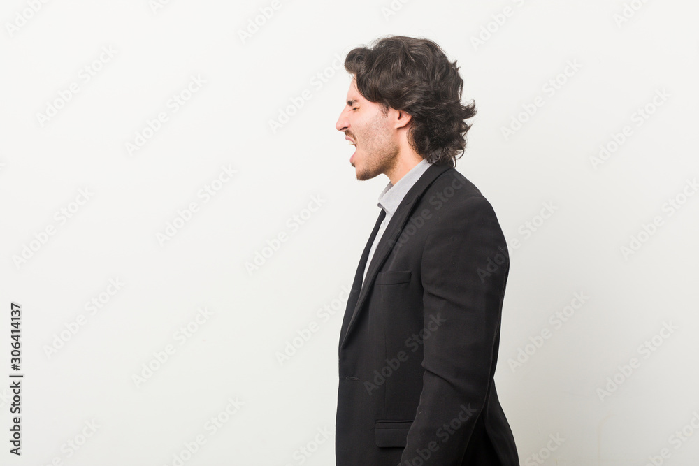 Young business man against a white background shouting towards a copy space Young business man against a white background shouting towards a copy space