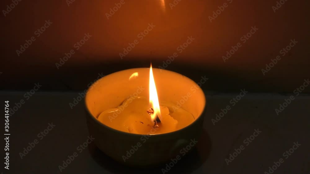 Candle lamp burning bright in dark against wall. Candle lamp burning bright in dark against wall.