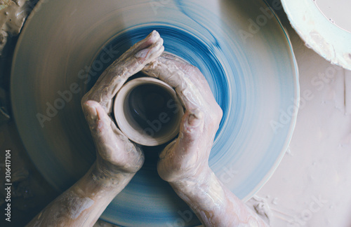 Close up the woman's hands modeling of clay on a potter's wheel In the pottery workshop. Handcraft Ceramic Work. Top View.