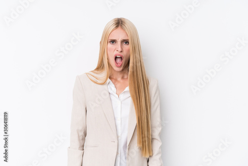 Young business blonde woman on white background screaming very angry and aggressive.
