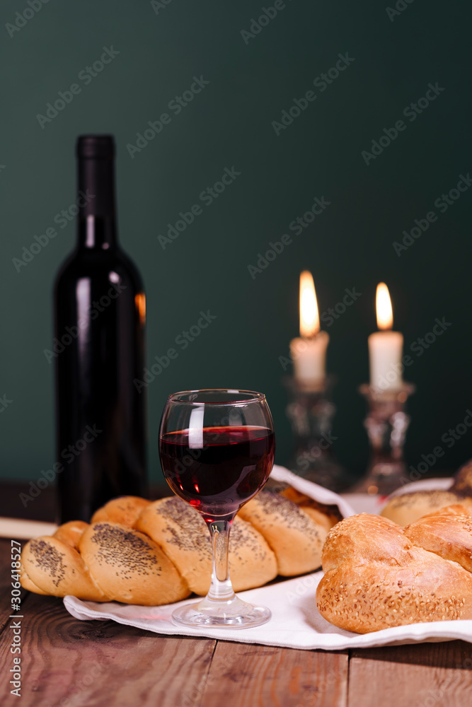 Shabbat Shalom. Challah bread, shabbat wine and candles on wooden table.