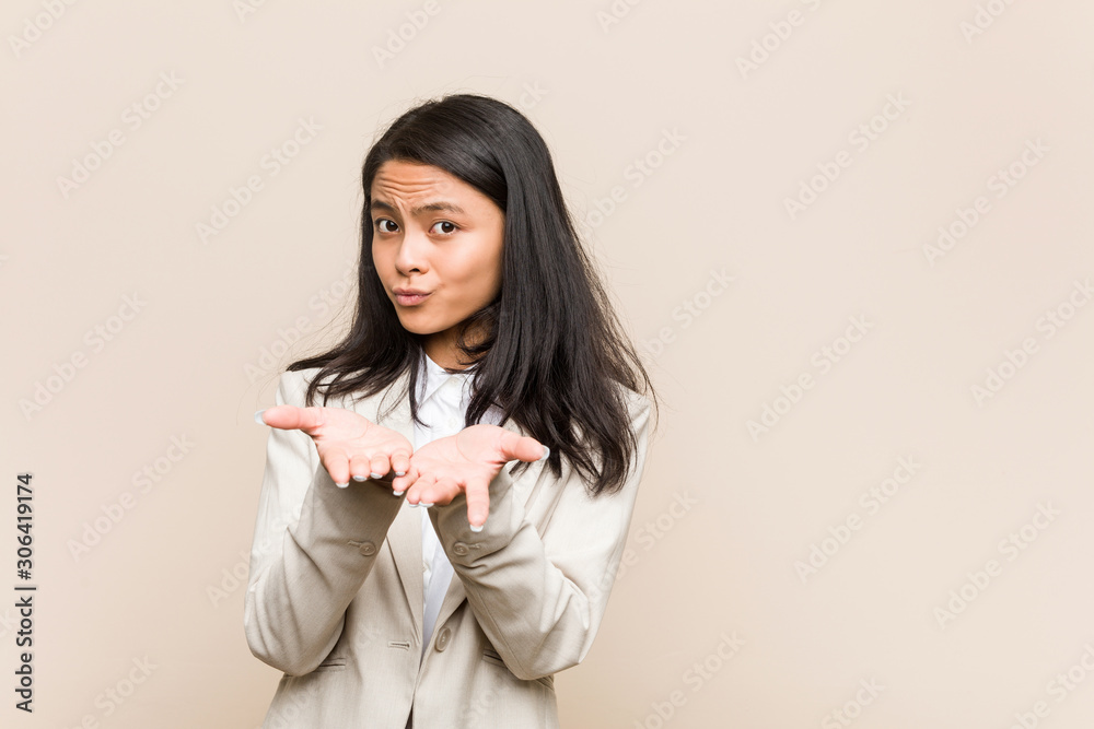 Young business chinese woman folding lips and holding palms to send air kiss. Young business chinese woman folding lips and holding palms to send air kiss.