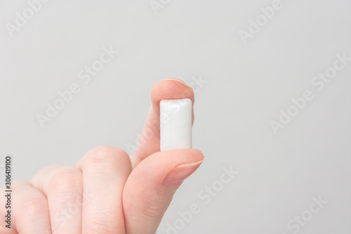 Obraz na plátně Hand with chewing gum, closeup, copy space