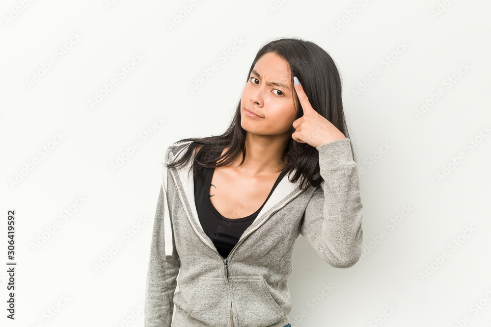 Young fitness chinese woman showing a disappointment gesture with forefinger. Young fitness chinese woman showing a disappointment gesture with forefinger.