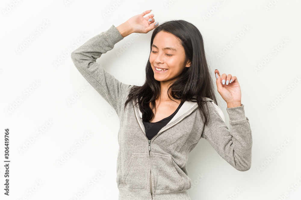 Young fitness chinese woman celebrating a special day, jumps and raise arms with energy. Young fitness chinese woman celebrating a special day, jumps and raise arms with energy.