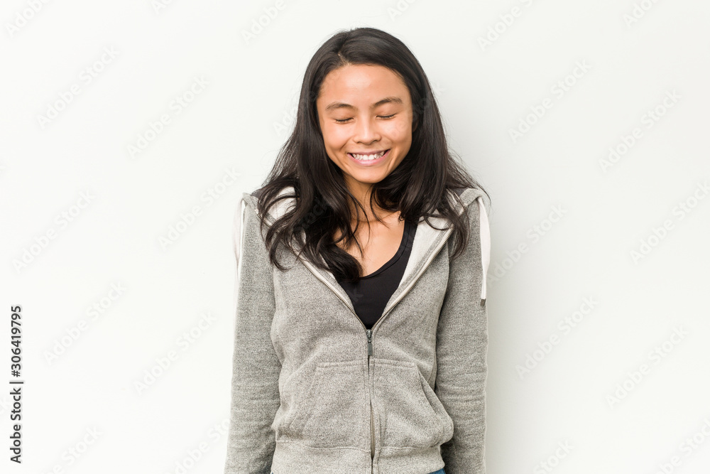 Young fitness chinese woman laughs and closes eyes, feels relaxed and happy. Young fitness chinese woman laughs and closes eyes, feels relaxed and happy.