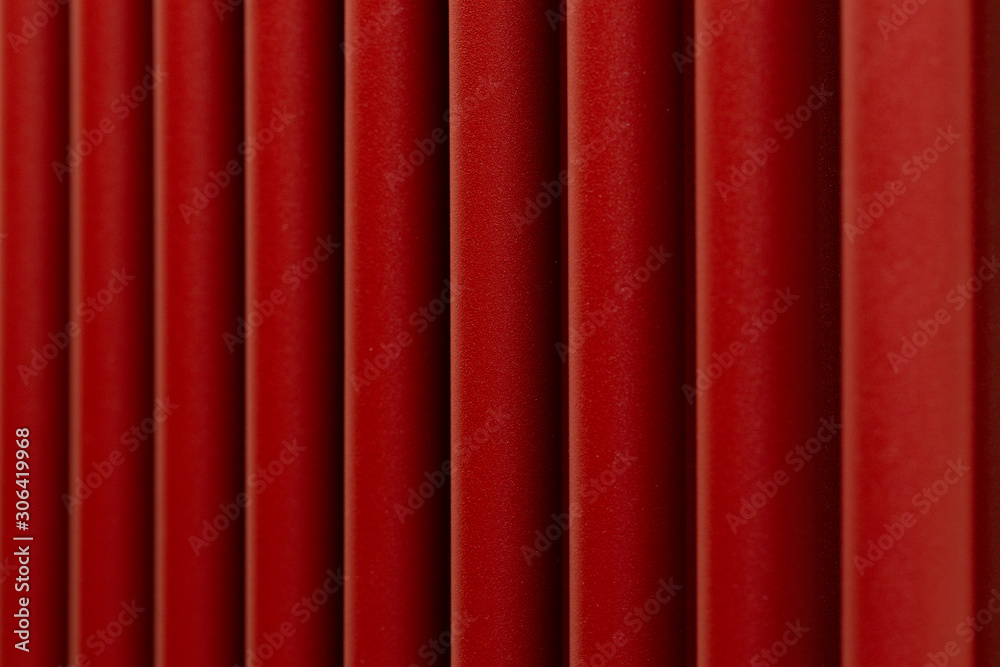 Abstract background in the form of vertical bright red wide stripes of a porous structure close-up. Abstract background in the form of vertical bright red wide stripes of a porous structure close-up.