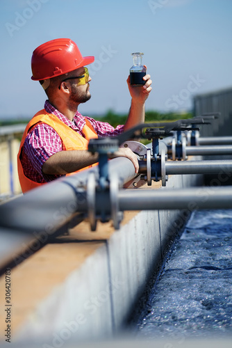 An engineer controlling a quality of water ,aerated activated sludge tank at a waste water treatment plant.  pollution  