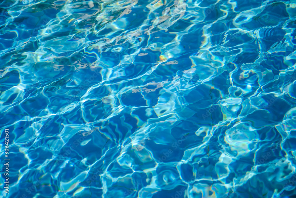 Wavy blue water in an outdoor pool or fountain on a bright sunny day