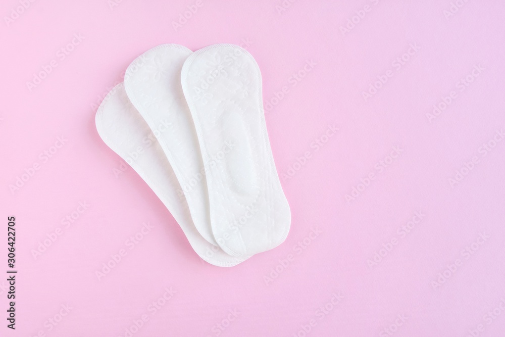 Daily soft cotton pads with selective focus on pink background with empty space for text. Menstrual pad. Women's health concept monthly period days. Woman critical days, menstruation cycle Daily soft cotton pads with selective focus on pink background with empty space for text. Menstrual pad. Women's health concept monthly period days. Woman critical days, menstruation cycle