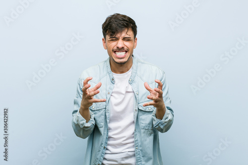 Canvas Print Young hispanic cool man upset screaming with tense hands.
