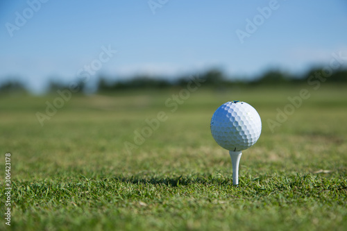 Beautiful green golf course with a golf ball in focus copy space mock up
