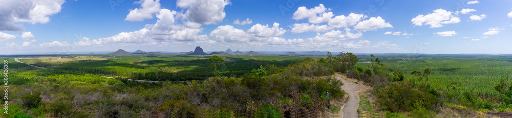 Panorama Australian landscape taking in Glass House Mountains, area of bush and farms with pine forests