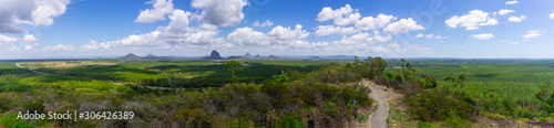 Panorama Australian landscape taking in Glass House Mountains, area of bush and farms with pine forests