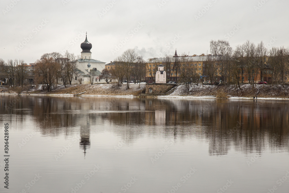 The old Church is reflected in the water of the great river. Urban landscape. Pskov, Russia.