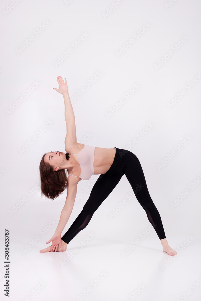 Young beautiful girl performs yoga exercises