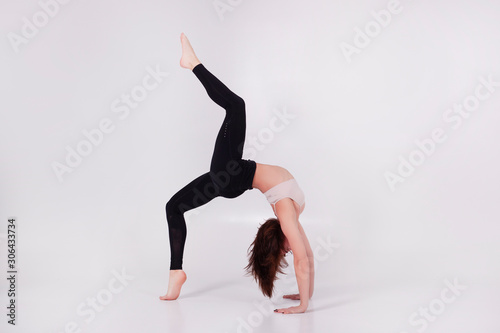 Young beautiful girl performs yoga exercises