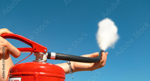 CLOSE UP: Unrecognizable person squeezes the handle of a fire extinguisher.