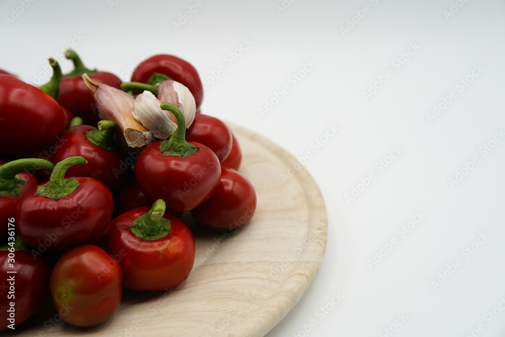 Close-up of red hot chili peppers on plate. Fresh spices ingredients on white background. Raw healthy vegetables