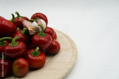 Close-up of red hot chili peppers on plate. Fresh spices ingredients on white background. Raw healthy vegetables