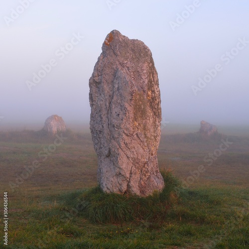 Single menhir view at Camaret sur mer at sunrise during fog