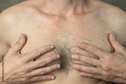 body of caucasian man with hands on breast
