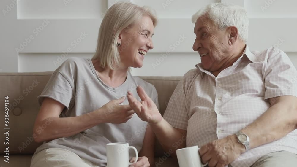 Happy old senior couple talking laughing drinking tea together Happy old senior couple talking laughing drinking tea together