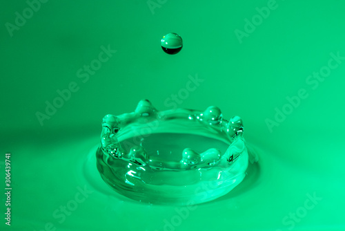 Goccia d'acqua che rimbalza con sfondo verde photo