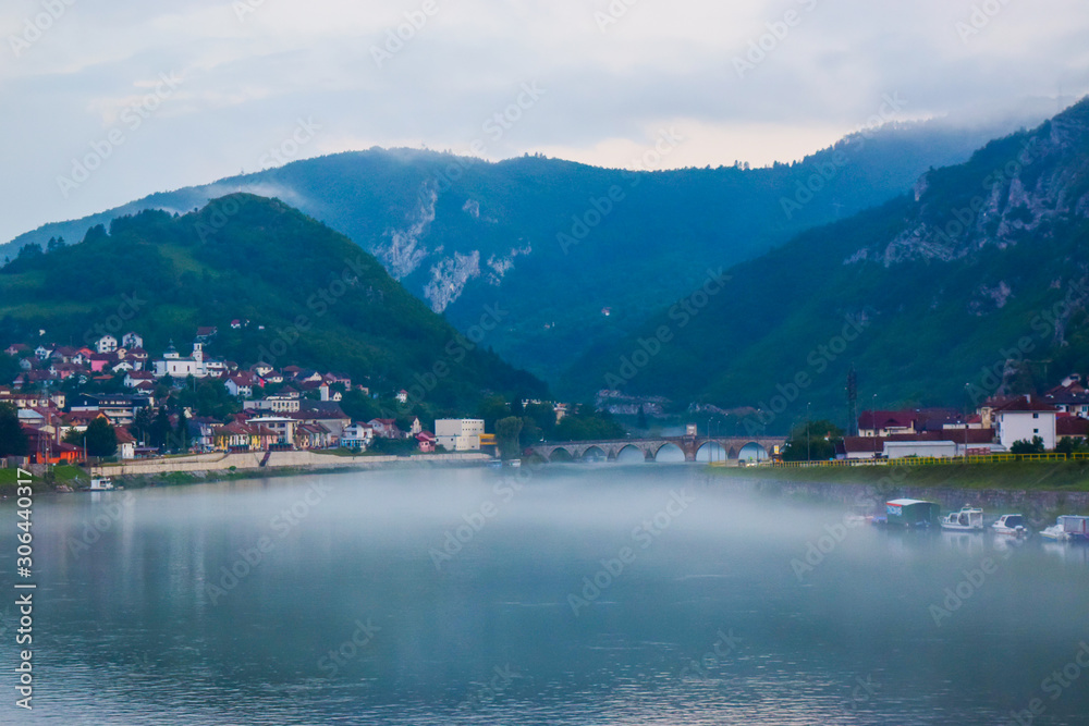 The Mehmed Pasa Sokolovic Bridge and Drina river in the evening fog. Visegrad. Bosnia and Herzegovina.