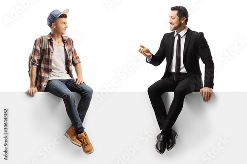 Businessman talking to a male student and sitting on a panel