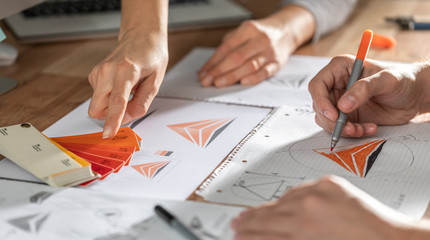 Graphic designer drawing sketches logo design.