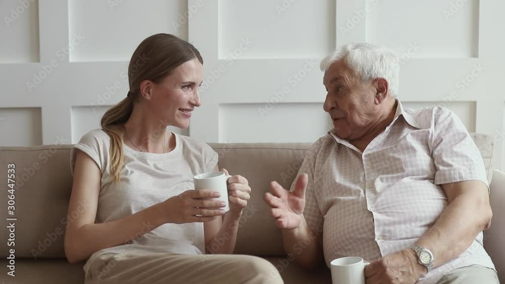 Happy senior retired father and adult daughter talking at home Happy senior retired father and adult daughter talking at home