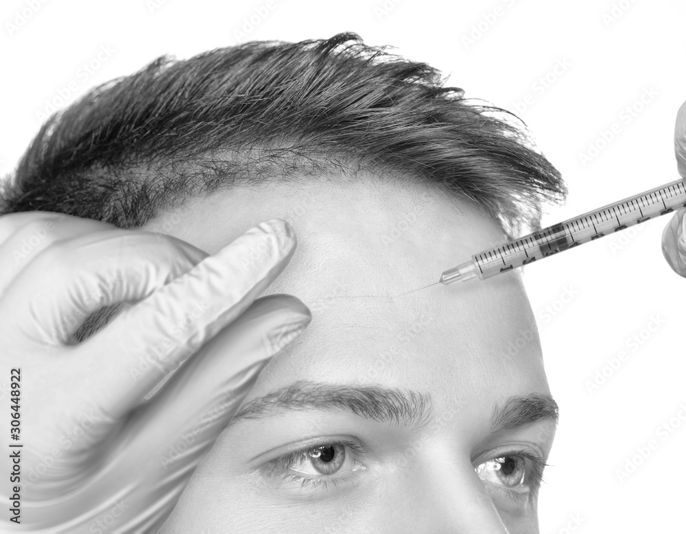 Obraz premium The doctor cosmetologist makes the Rejuvenating injections procedure for tightening and smoothing wrinkles on the face skin of a handsome man with clean skin in a beauty salon.Cosmetology concept.
