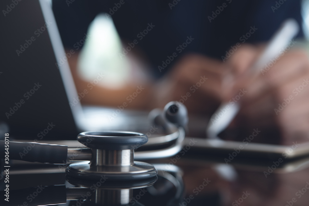 Doctor working on laptop computer and tablet Doctor working on laptop computer and tablet