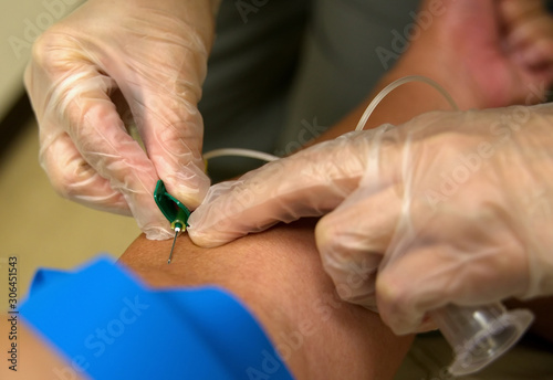 Close up of a Phlebotomist needle getting blood from a patient for laboratory testing. photo